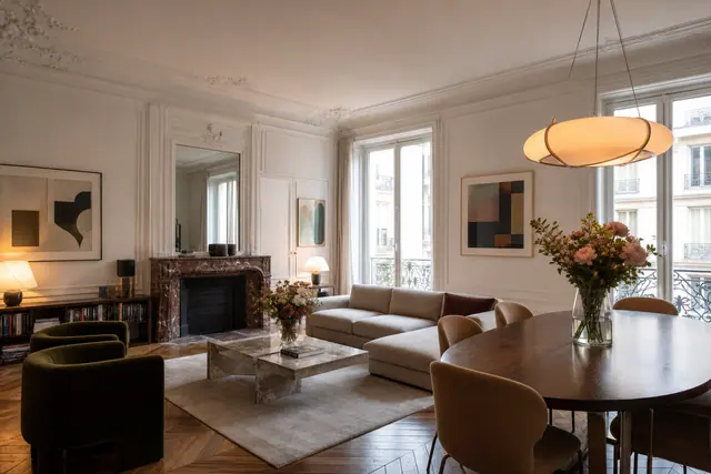 Salon haussmannien modernisé avec parquet ancien, moulures, fleurs et mobilier contemporain.