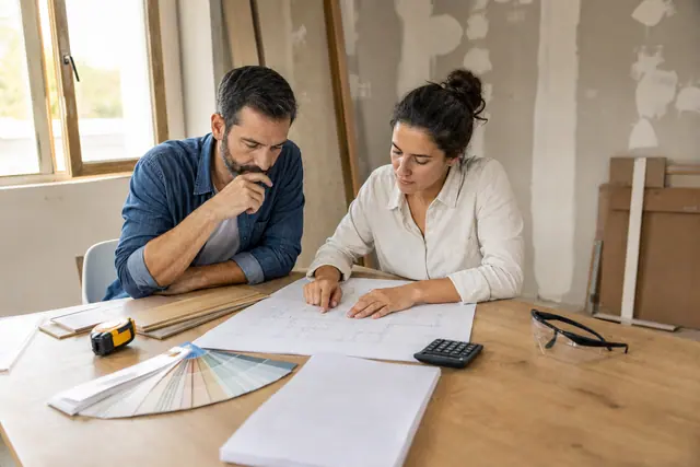 Couple préparant le budget et le calendrier de rénovation d’une pièce.