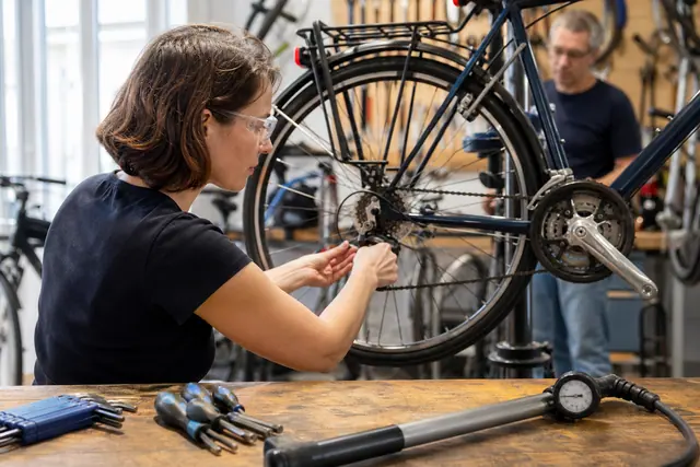 Participant réglant la transmission de son vélo sur un pied d’atelier.