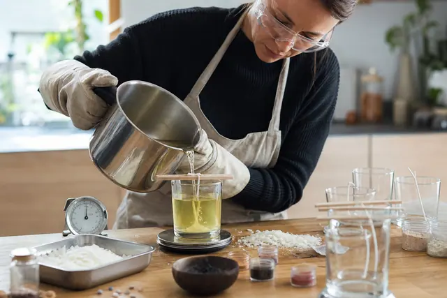 Coulée de cire dans un pot avec mèche centrée et protections.