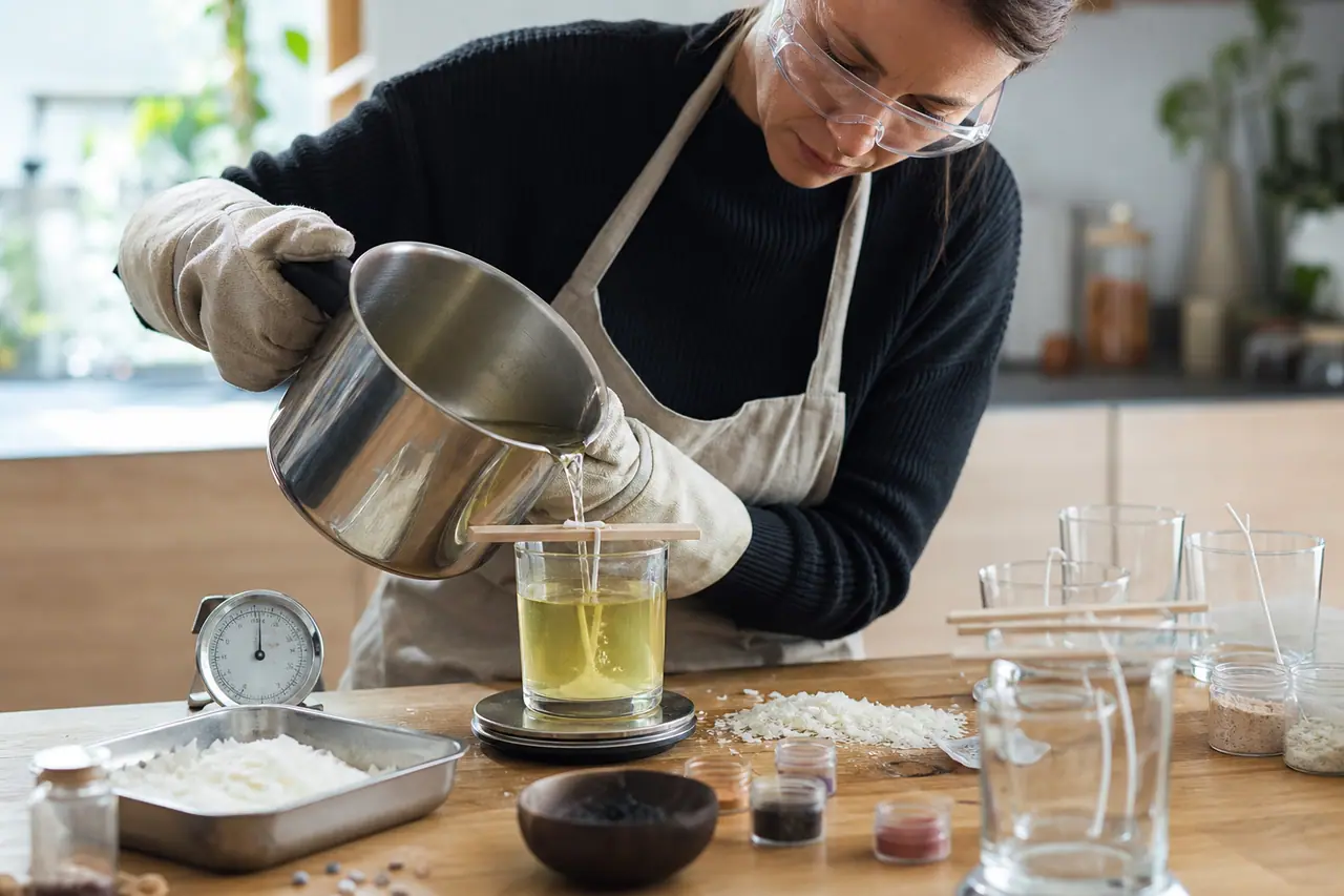 Coulée de cire dans un pot avec mèche centrée et protections.