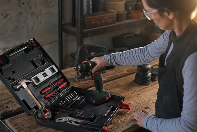Établi équipé d’une perceuse-visseuse et d’outils manuels pour petits travaux.