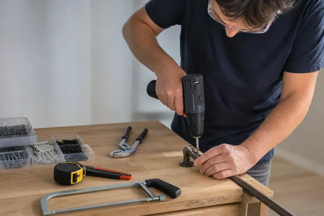 Trois outils essentiels posés près d’une tringle en cours de fixation