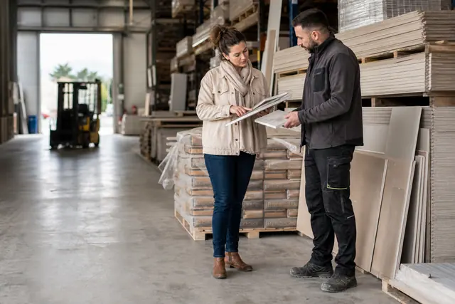 Cliente et conseiller comparent des matériaux dans un dépôt de bricolage local.
