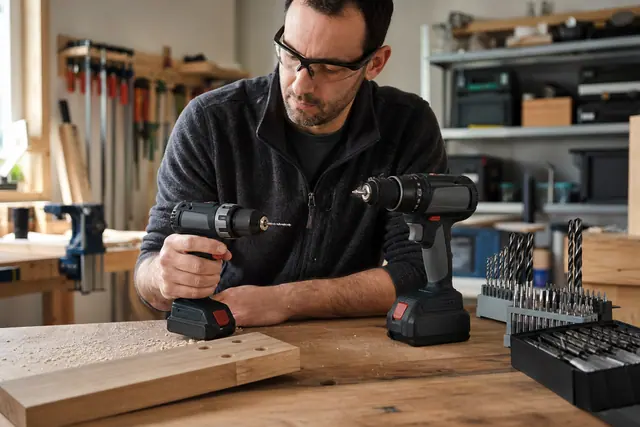 Deux perceuses-visseuses 12 V et 18 V comparées sur un établi.