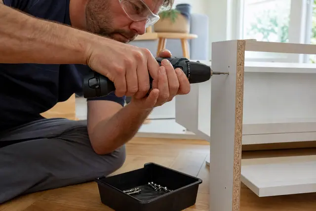 Perceuse-visseuse compacte utilisée pour assembler un meuble en panneaux mélaminés.