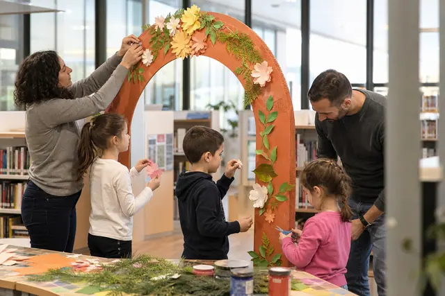 Participants décorant une arche en carton stable lors d’un atelier créatif en médiathèque