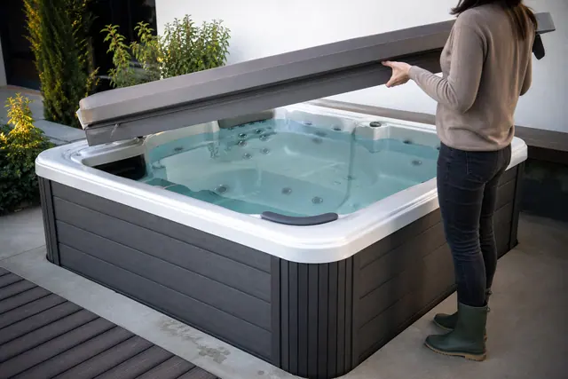 Spa rigide couvert sur dalle stable dans un jardin résidentiel contemporain.