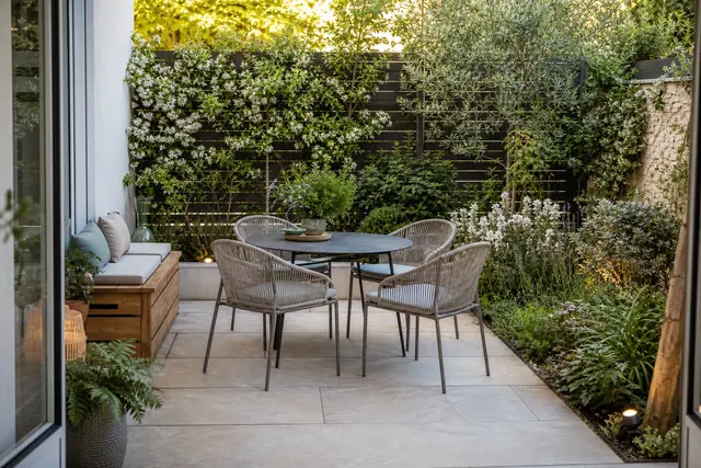 Petit jardin urbain structuré avec terrasse, grimpantes et coin repas convivial