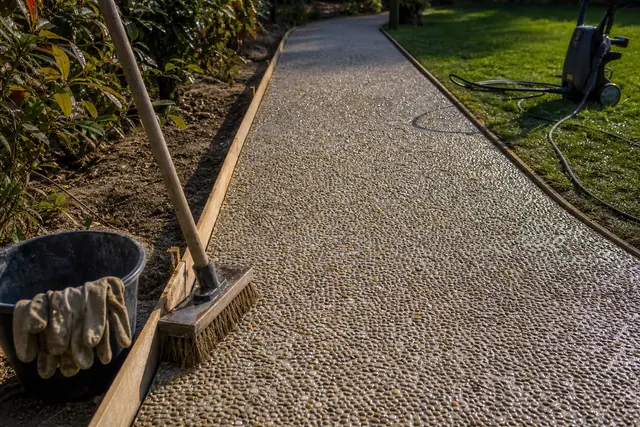 Allée en béton désactivé aux granulats apparents fraîchement lavée dans un jardin