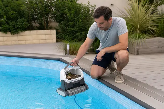 Robot compact nettoyant le fond d’une piscine hors sol à liner bleu.