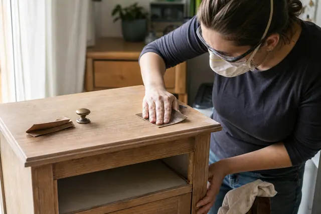 Préparation manuelle d’une table de chevet avant peinture et changement de poignée