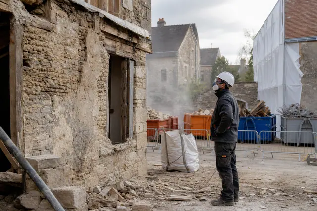 Chef de chantier inspectant une maison ancienne avant déconstruction sélective et tri des matériaux.