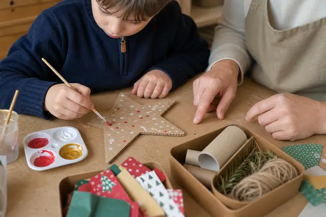 Enfant décorant une étoile en carton récupéré sur une table protégée