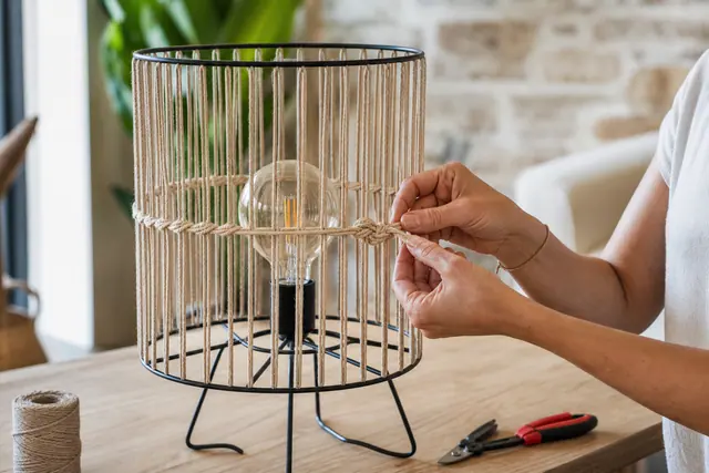Lampe à poser avec abat-jour ajouré en corde naturelle et ampoule LED.
