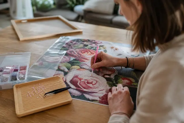 Toile de diamond painting en cours, strass rangés et cadre prêt à poser.