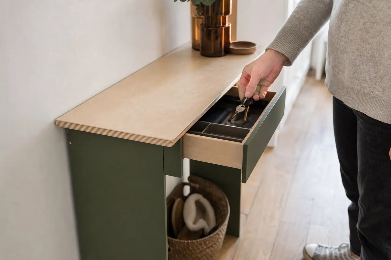 Console d’entrée peu profonde en bois avec caissons verts et rangements discrets.