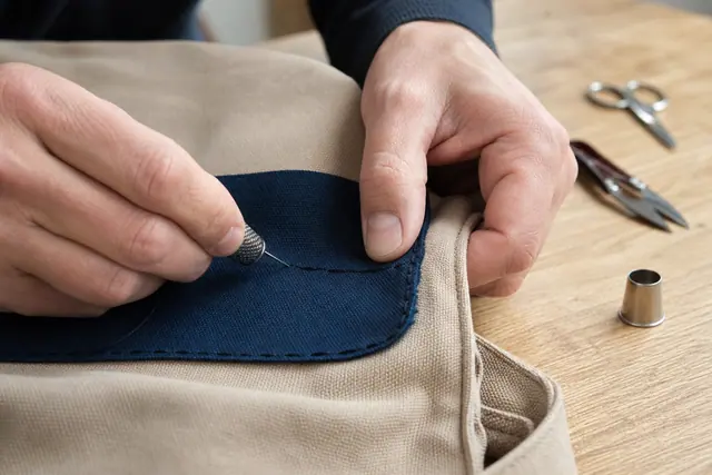 Patch bleu cousu à la main sur un sac en toile beige
