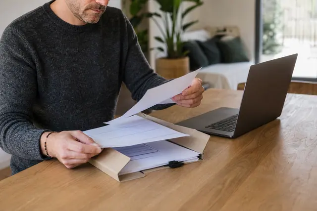 Particulier classant facture, bon de commande et preuve de paiement à domicile.