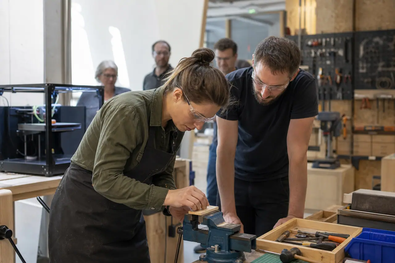 Débutante encadrée dans un fablab lors d’un atelier de fabrication bois.