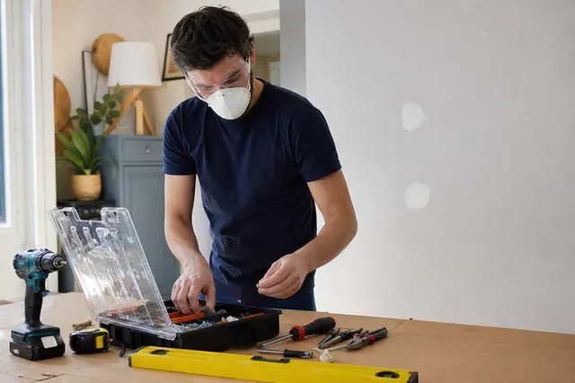 Débutant préparant ses outils de bricolage sur une table protégée