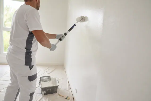 Application soignée d’une peinture laquée blanche au rouleau sur mur lissé.