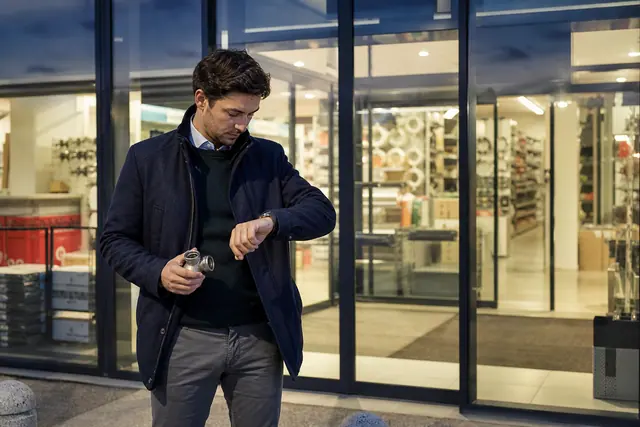 Client devant une entrée de magasin fermée en début de soirée.