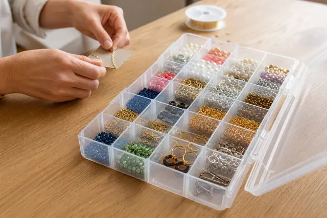Organisateur transparent ouvert avec perles, bijoux et petites vis soigneusement séparés.