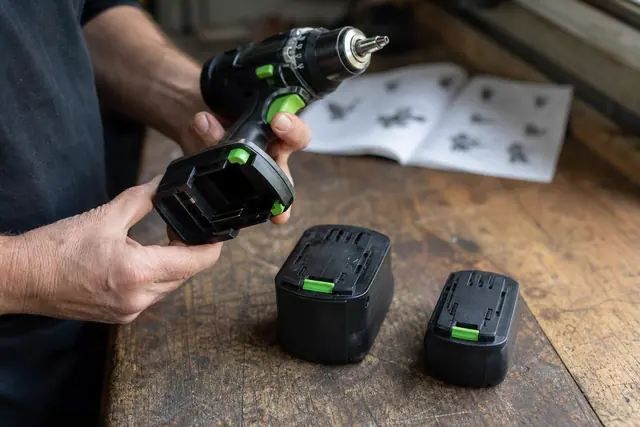 Bricoleur vérifiant le logement de batterie d’une visseuse sans fil.