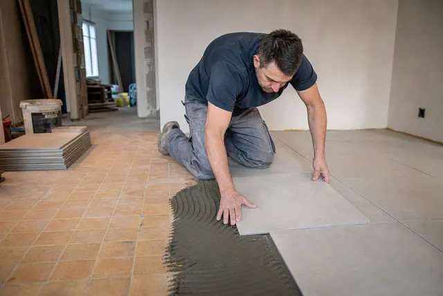 Pose de carrelage neuf directement sur un ancien sol carrelé encore visible en bordure