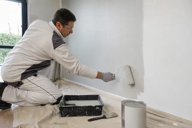 Application au rouleau d’une peinture satinée sur mur en placo préparé.