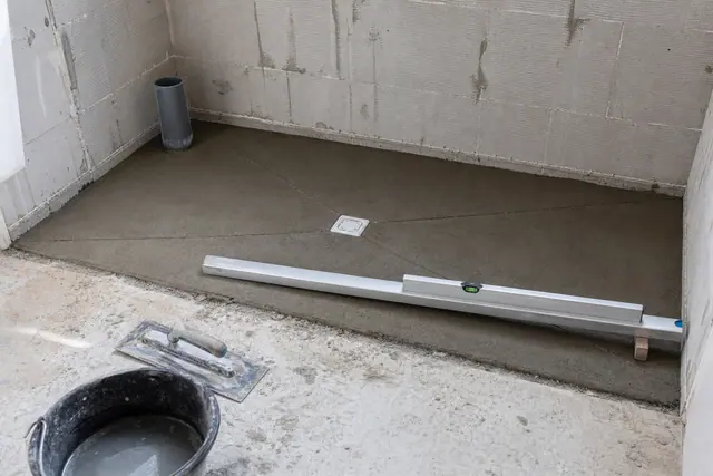 Chape de pente d’une douche à l’italienne tirée à la règle vers une bonde carrée centrale