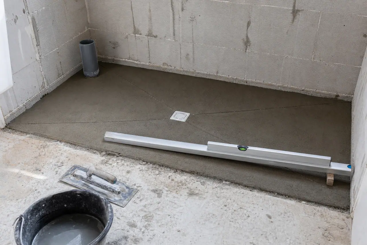 Chape de pente d’une douche à l’italienne tirée à la règle vers une bonde carrée centrale