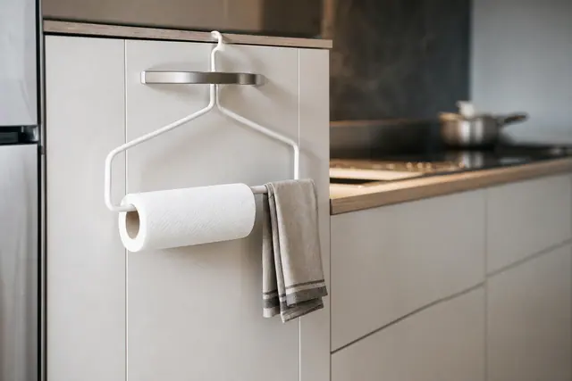 Cintre métallique propre suspendu à un placard avec rouleau d’essuie-tout léger.