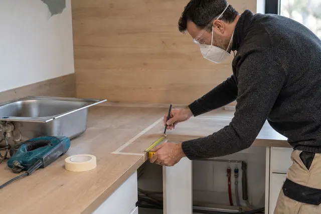 Traçage précis d’un évier encastrable sur un plan de travail de cuisine.