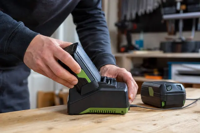 Batterie Parkside X20V insérée dans son chargeur sur un établi ventilé