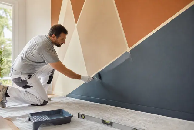 Application précise de peinture sur un mural géométrique au ruban de masquage.