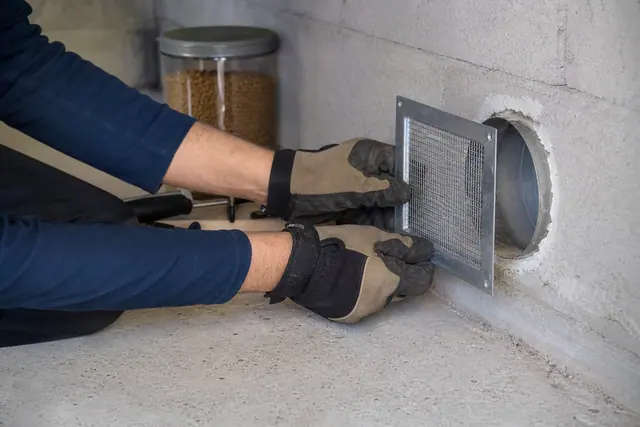 Calfeutrement métallique d’un passage de tuyau dans un garage pour empêcher les souris.
