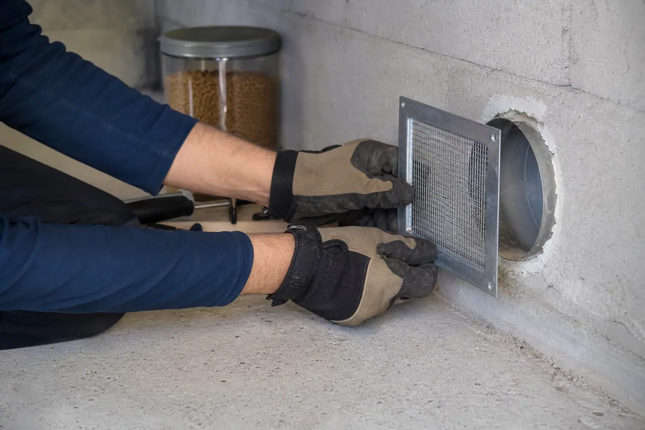Calfeutrement métallique d’un passage de tuyau dans un garage pour empêcher les souris.