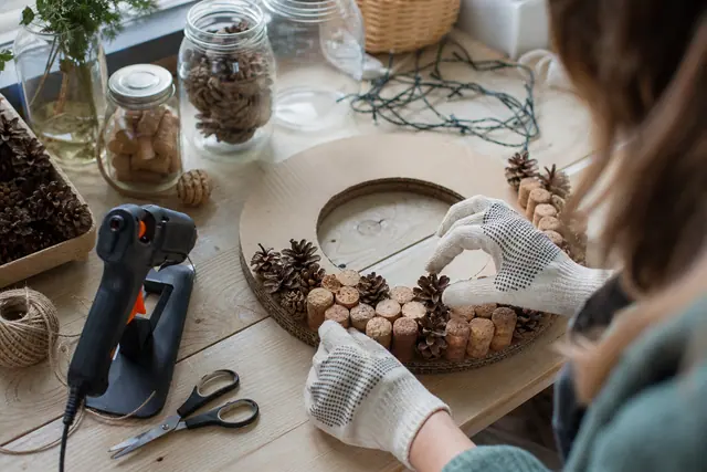 Fabrication d’une couronne de Noël avec bouchons, carton et pommes de pin.