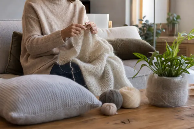 Coussin et plaid en mohair tricotés dans un salon lumineux
