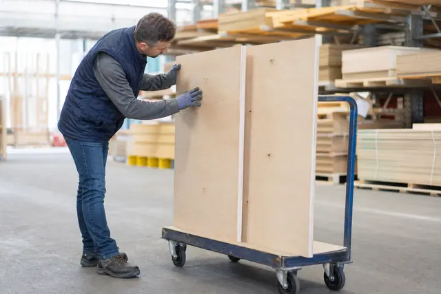 Client comparant deux panneaux de bois sur un chariot en magasin.