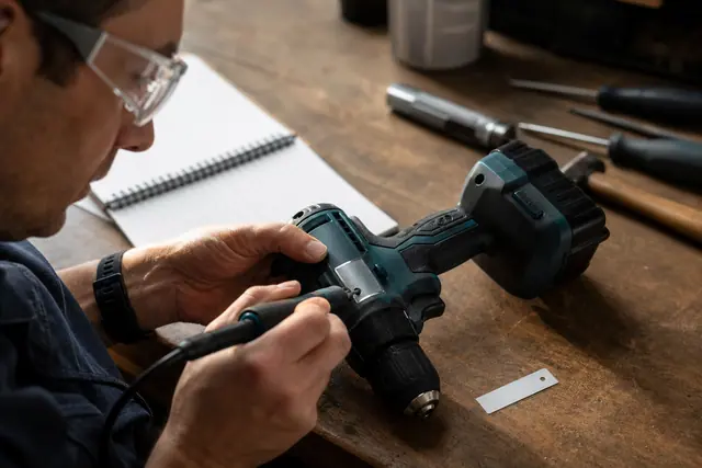 Gravure d’un identifiant sur une perceuse fixée à un établi
